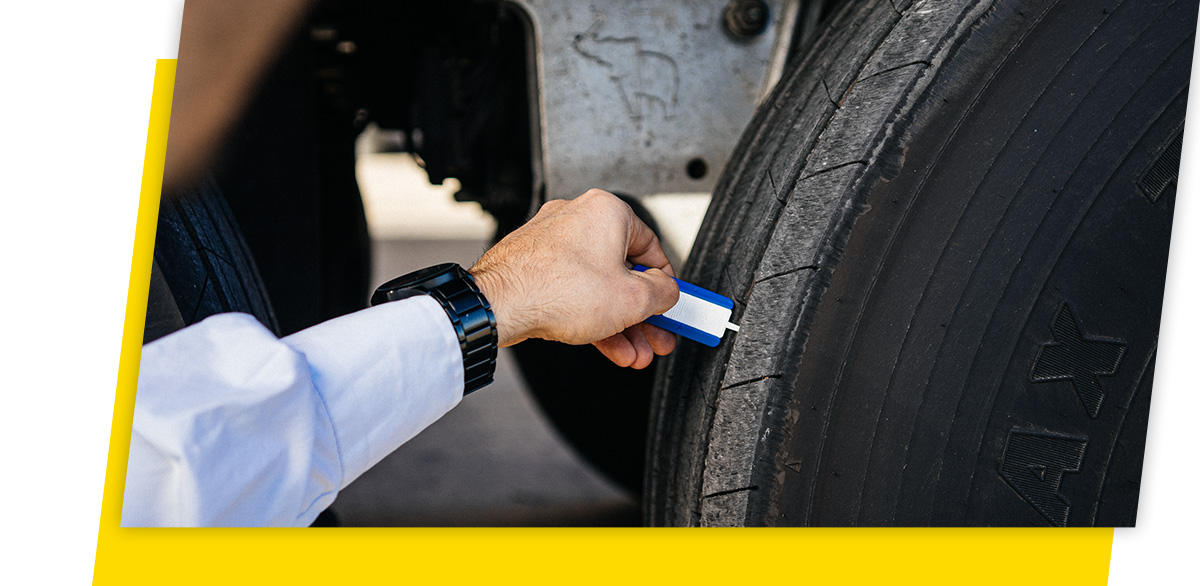 Person measuring the tyre tread depth