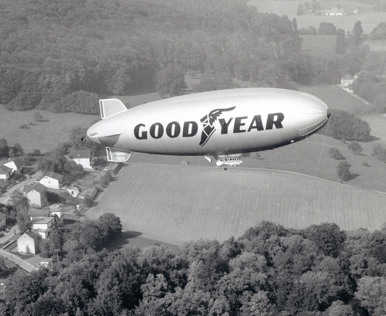 Image of Goodyear Blimp flying over houses